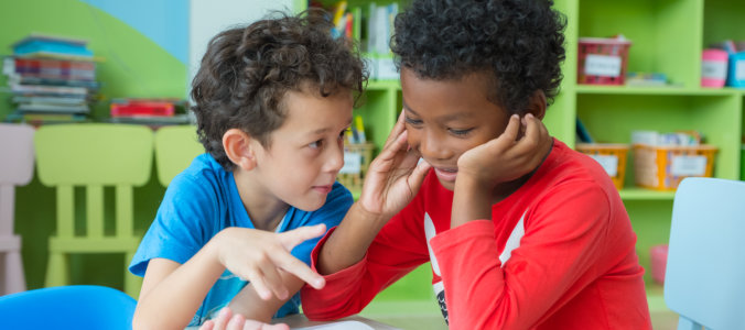 two boys sitting in a development center setting