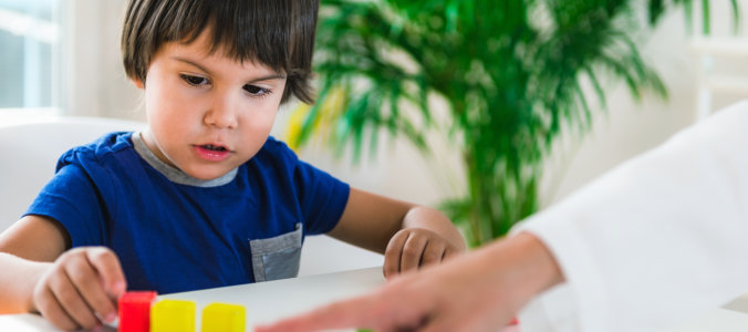 boy playing colored memory blocks